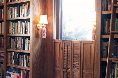 Home Library Bookshelves with Pink and Brass Tassel Sconces