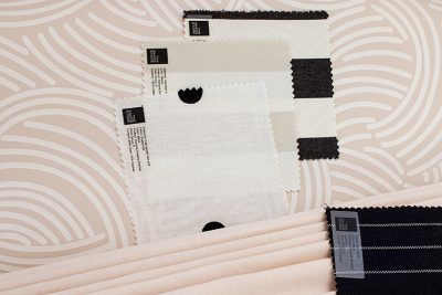 Fabric samples from The Shade Store against pink Tourbillon Farrow & Ball wallpaper