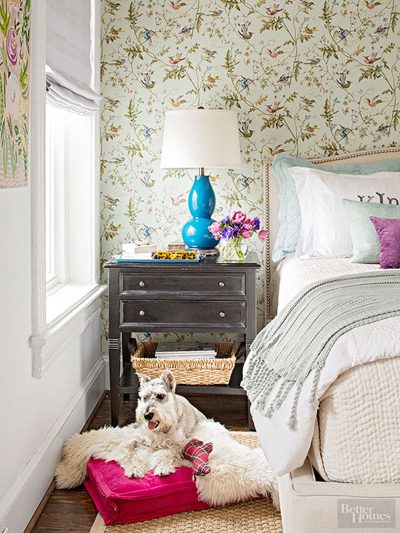 Wallpapered Bedroom with Black Side Table and Teal Lamp