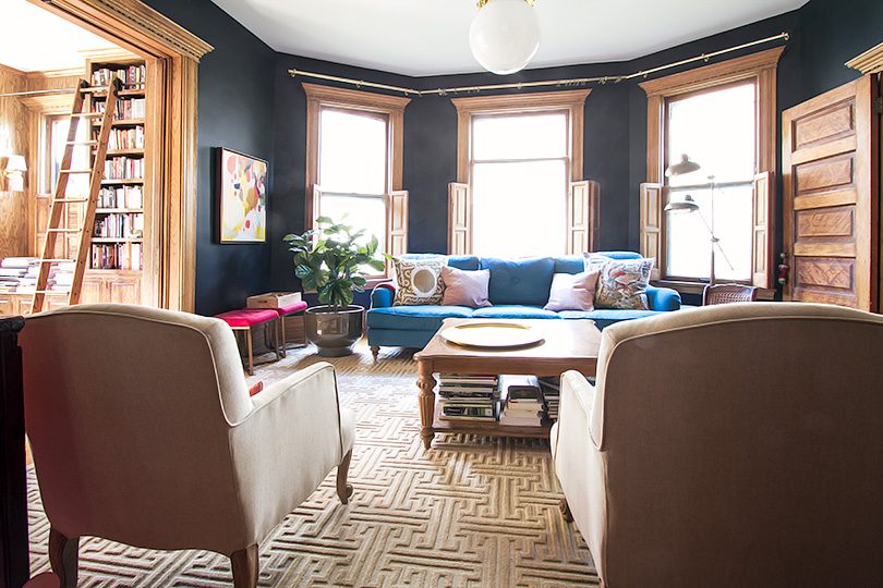 Living Room with Black Walls, Teal Sofa, and Annie Selke Rug