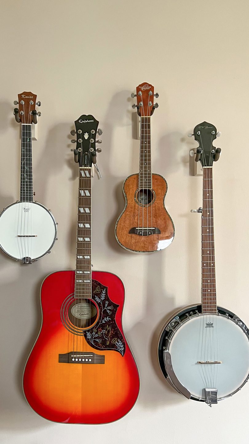 Banjolele, Acoustic Guitar, Ukulele, and Banjo Hanging on Wall
